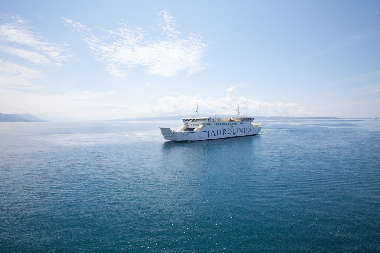 gallery-02 Jadrolinija ferry sailing on the calm Adriatic Sea under a bright blue sky.